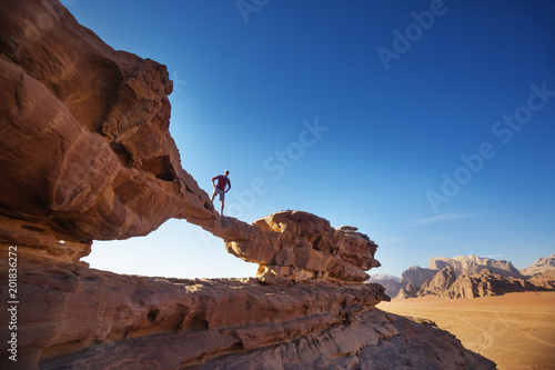 Tourist on rock. Wadi Ram desert. Stone bridge. Jordan landscape