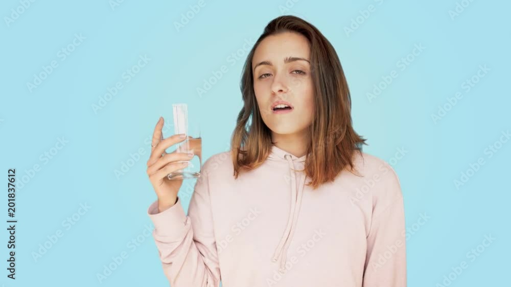 Beautiful, young and healthy young woman or teenager lives healthy lifestyle, hydrates body, drinks water from big glass, feels refreshed and energized, full of energy. enjoys drink in summer heat Beautiful, young and healthy young woman or teenager lives healthy lifestyle, hydrates body, drinks water from big glass, feels refreshed and energized, full of energy. enjoys drink in summer heat