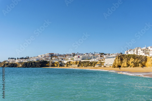 Sandy beach and cliffs in white city of Albufeira, Algarve, Portugal © eunikas