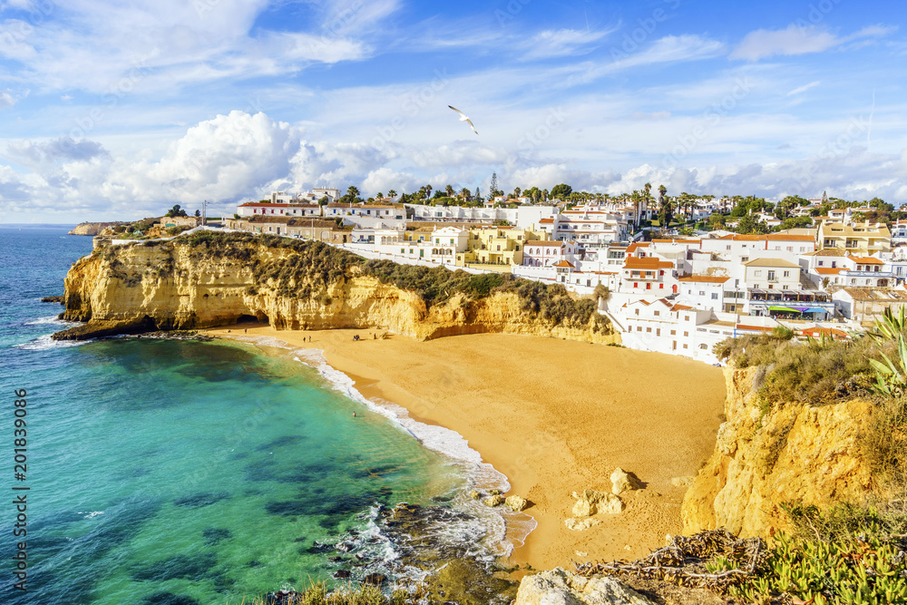 Sandy beach between cliffs and white architecture in Carvoeiro, Algarve, Portugal