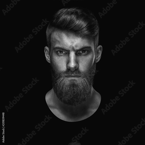 Fotografía Black and white portrait of serious young man Isolated on black background and l
