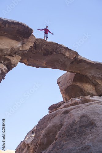 Tourist on rock. Wadi Ram desert. Stone bridge. Jordan landscape