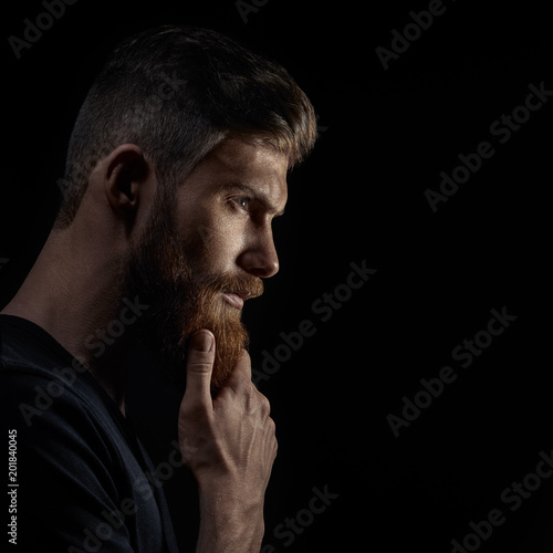 Profile view of handsome stylish young man with undercut hairstyle, beard with copy space