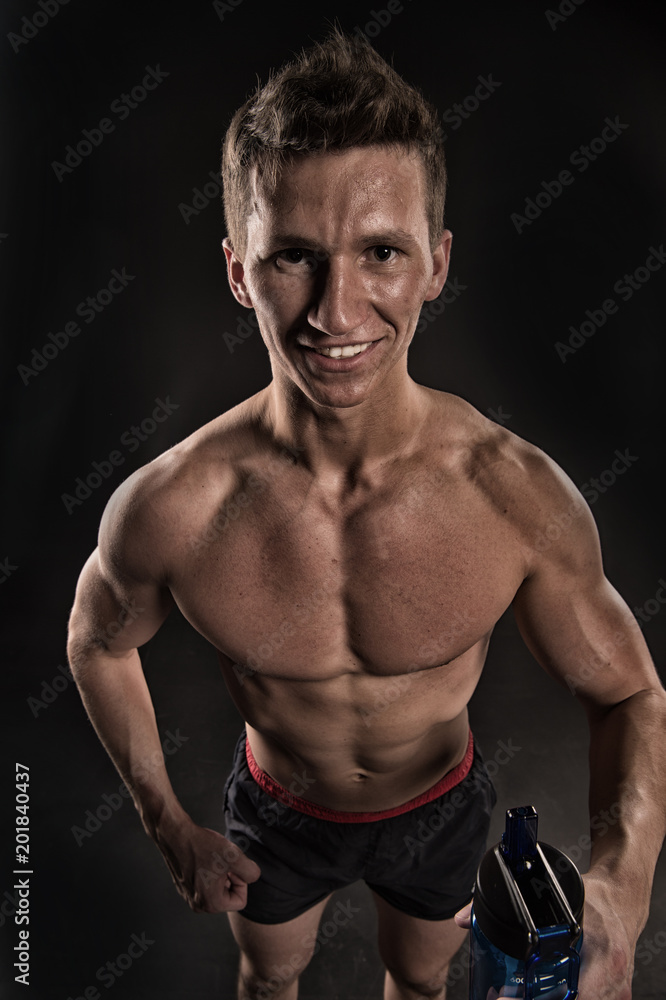 Thirsty athlete smiling with bottle of water. Sportsman smile with sport bottle. Happy man with fit body and torso. Thirst and dehydration concept. Drinking water after training and workout, vintage