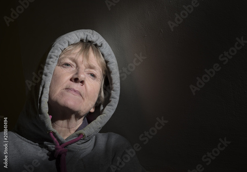 Mature woman with depression and anxiety on a dark background with copy space 