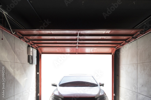 Garage open the door for car is parked in garage.