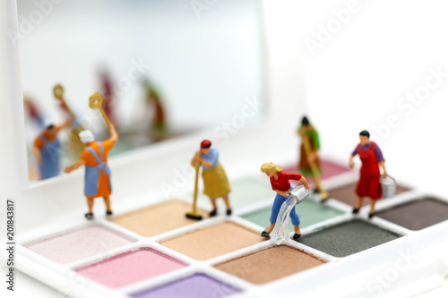 Miniature people : Maid or Housewife cleaning on Makeup products with cosmetic beauty products.