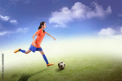 Side view of asian soccer player woman in action