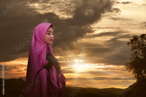 Young asian female muslim praying with hijab