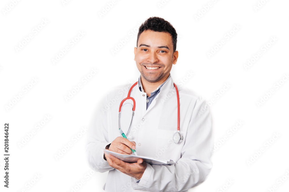 Doctor with stethoscope around his neck looking at the camera and writing recipe Doctor with stethoscope around his neck looking at the camera and writing recipe