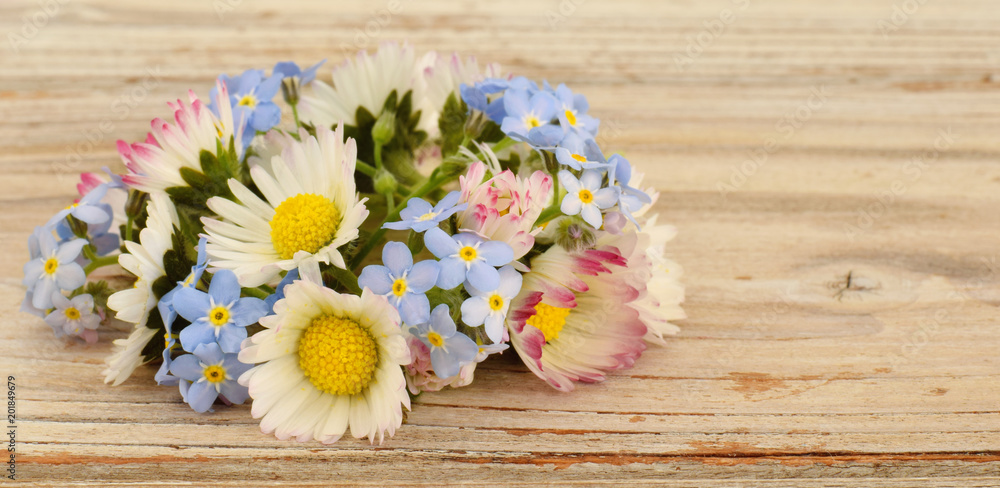 Meadow flowers chamomile or daisies and forget me not closed up on old desk Meadow flowers chamomile or daisies and forget me not closed up on old desk