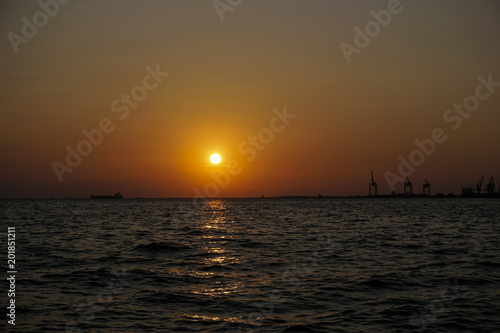 Sea level sunset with ship and port cranes landscape view.Sunset at Thessaloniki, Greece waterfront. © bestravelvideo