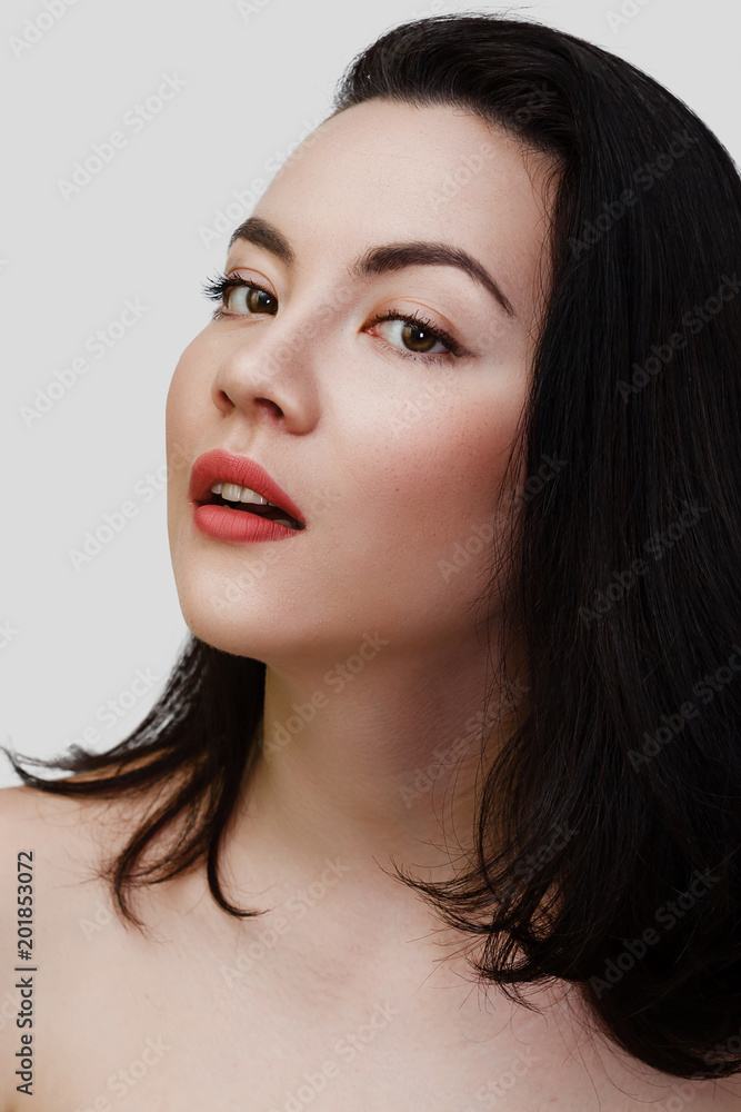 Fototapeta premium Young sexy lady with clean skin red lips and black straight hairstyle. Mixed race Caucasian Asian female model isolated on gray background