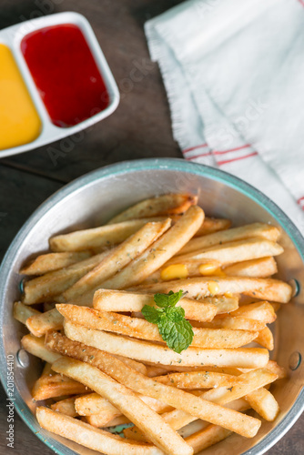 French fries on pan with tomato sauce and cheese sauce.