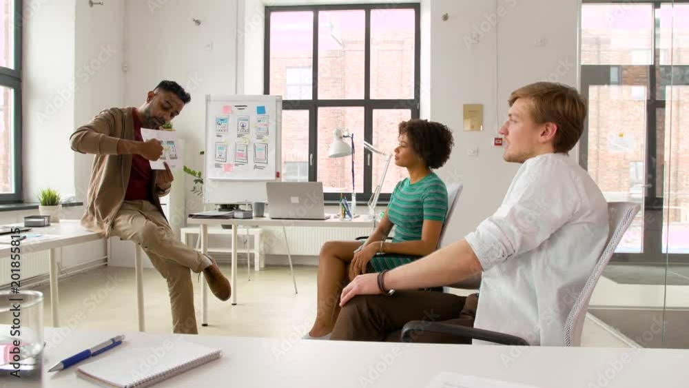 business, technology and software development concept - man showing user interface mockup to creative team at office business, technology and software development concept - man showing user interface mockup to creative team at office