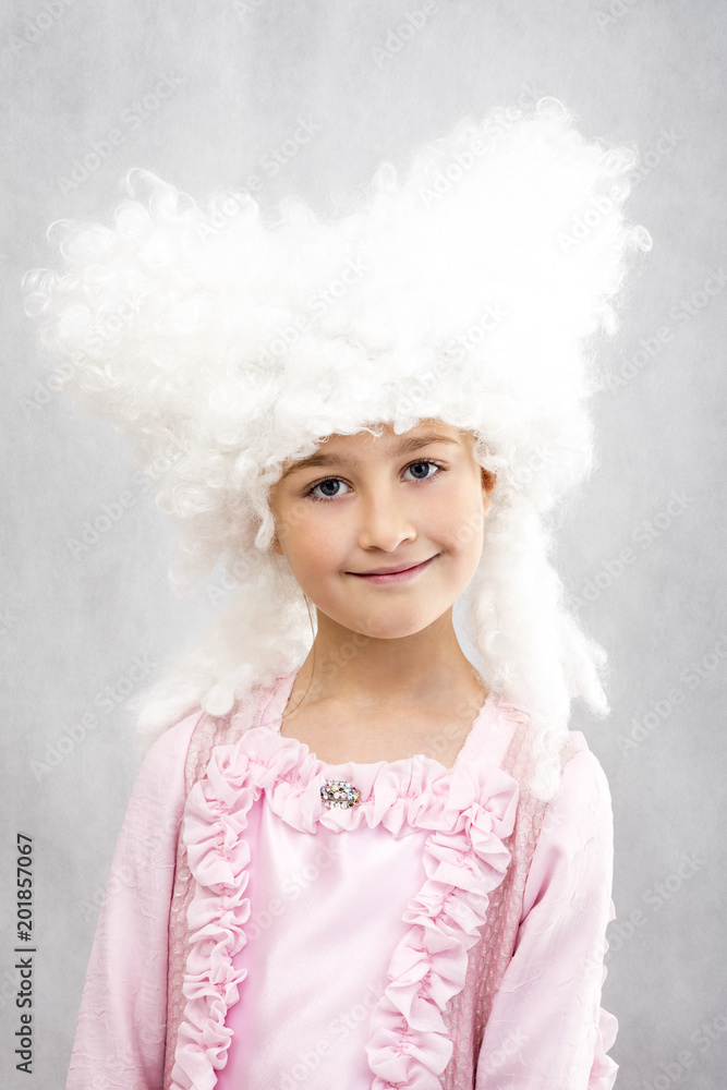 Smiling happy young girl in retro white wigs and princess pink dress. Smiling happy young girl in retro white wigs and princess pink dress.