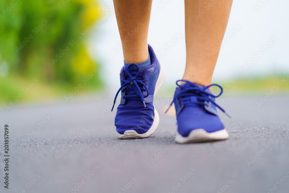 Woman feet running on road, Healthy fitness woman training