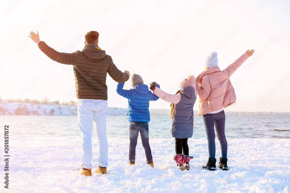 Obraz premium Happy family near river on winter day