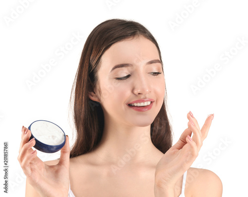 Teenage girl with acne problem using cream against white background