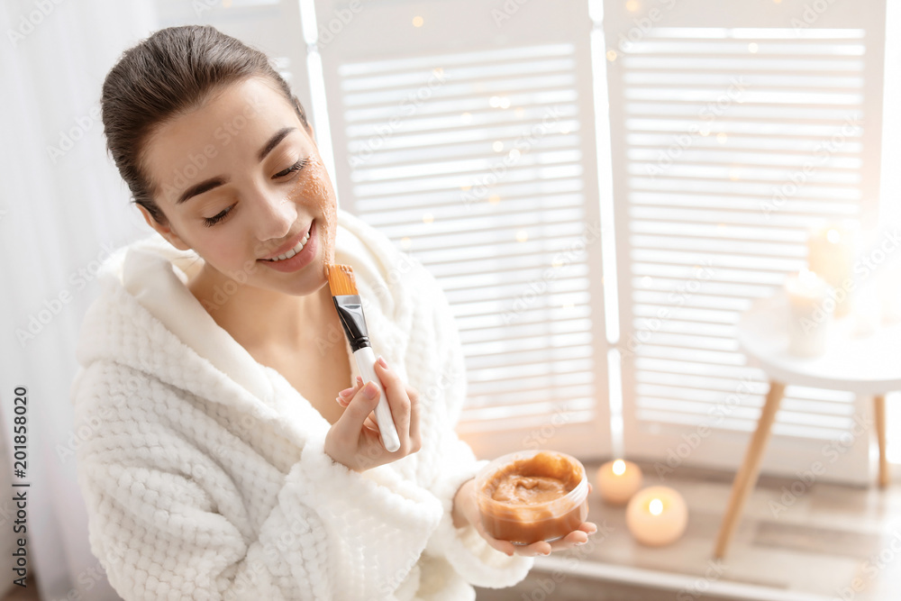 Young woman applying natural scrub on face in bathroom Young woman applying natural scrub on face in bathroom