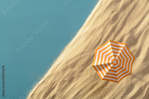 Beach umbrella on sandy texture