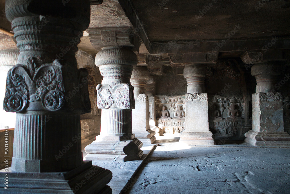 Ancient bas-relief with Buddha and stone columns in Ellora caves, Maharashtra, India