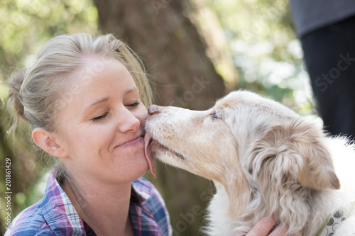 A woman being licked on the face by her dog photo