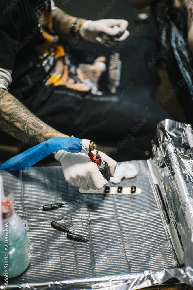 Master tattooing a back woman Master tattooing a back woman