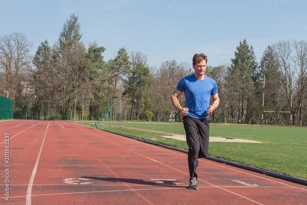 Obraz premium Adult male athlete running on sports field