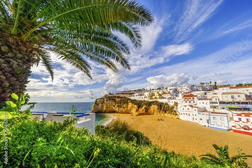 Fototapeta Naklejka Na Ścianę i Meble -  Sandy beach surrounded by cliffs with palm trees in Carvoeiro, Algarve, Portugal