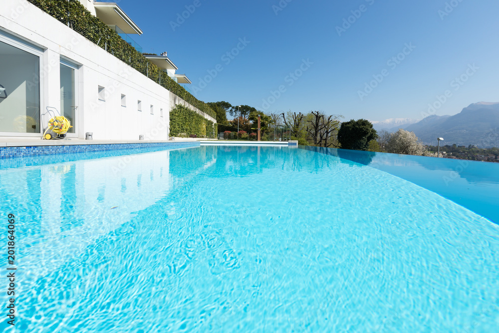 Exterior of building with swimming pool overlooking the hills