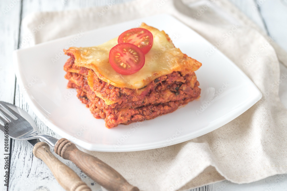 Portion of lasagne on the white plate Portion of lasagne on the white plate