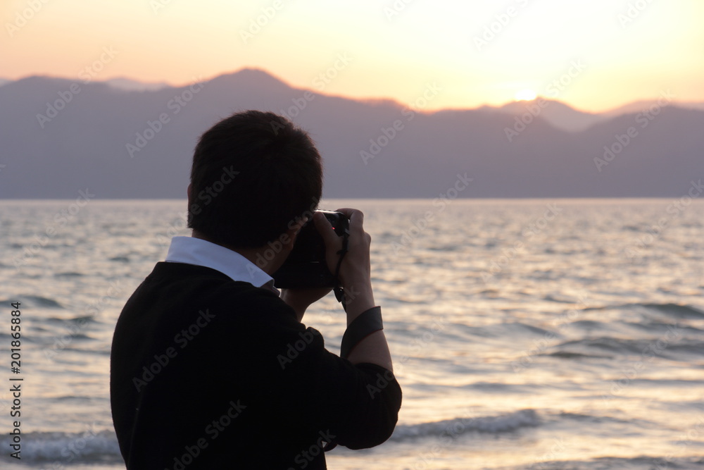 夕日を撮影するカメラマン