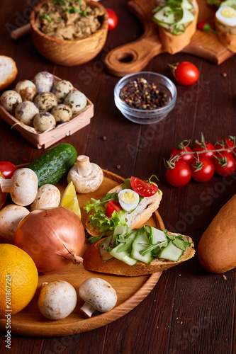 Breakfast still life with sandwiches, quail eggs, spicies and fresh fruits and vegetables, selective focus