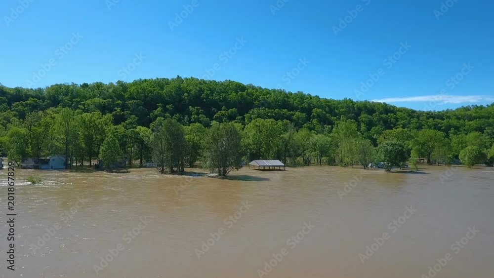Aerial over a flooded river showing homes under water Aerial over a flooded river showing homes under water