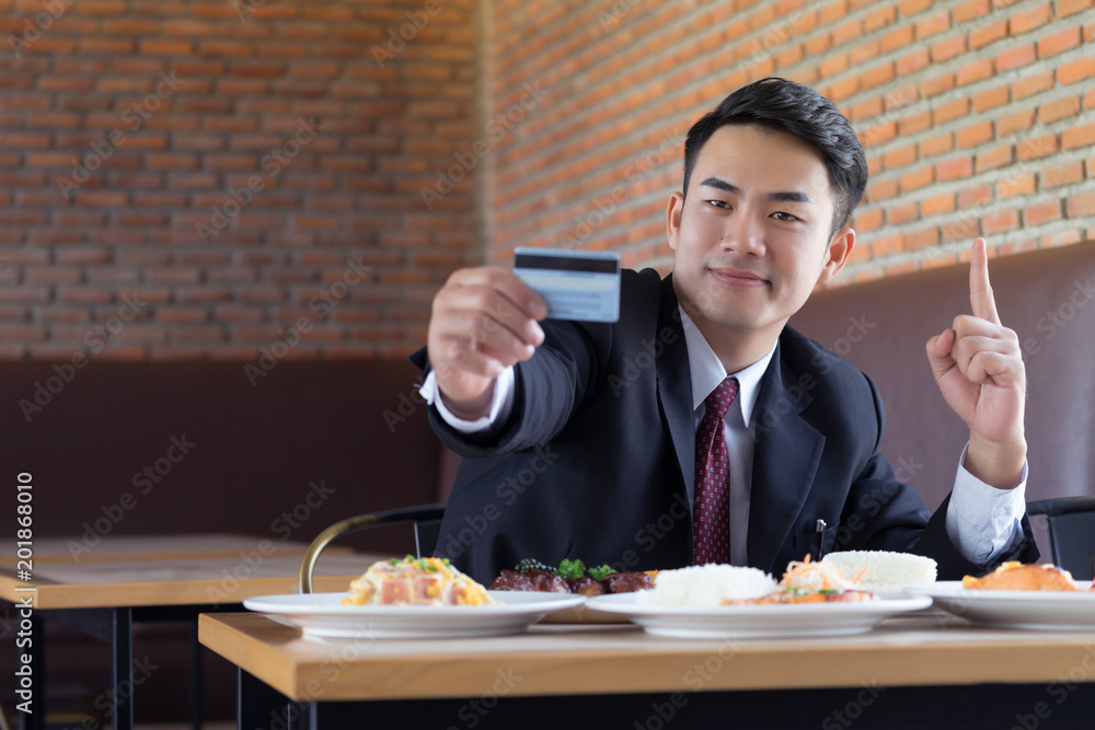 Businessman holding credit card for pay food at resterunt. Businessman holding credit card for pay food at resterunt.