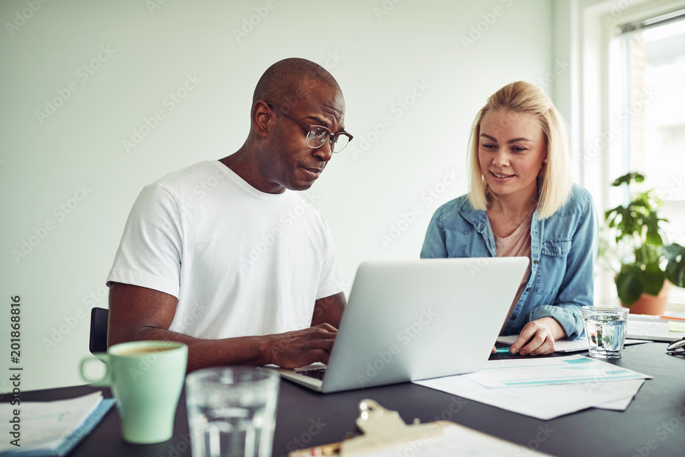 Two businesspeople working online with a laptop together Two businesspeople working online with a laptop together