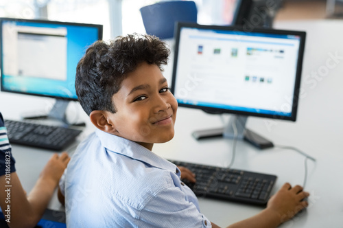 Fototapeta School boy using computer