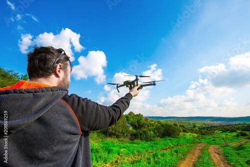 Man holds small compact drone in his hands. Pilot launches quadrupter from his palm. Drone ready to go on gps.