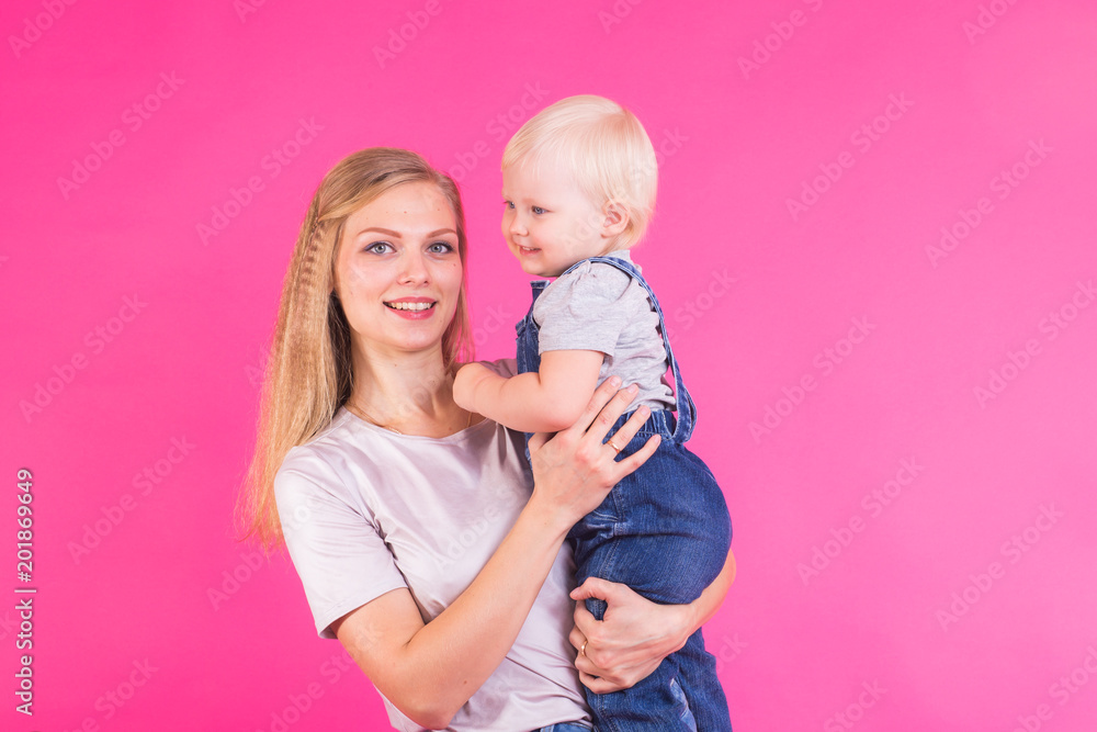 young mother and daughter having fun together on pink background young mother and daughter having fun together on pink background