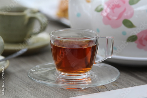 A cup of hot tea on wooden table.