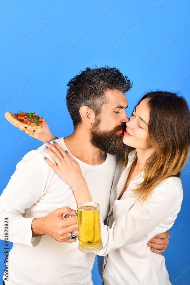 Happy family time. Husband and wife eating pizza. Couple sharing pizza and eating together happily. Beautiful young couple drinking beer, eating pizza. Loving couple kissing. Love, lifestyle concept. Happy family time. Husband and wife eating pizza. Couple sharing pizza and eating together happily. Beautiful young couple drinking beer, eating pizza. Loving couple kissing. Love, lifestyle concept.