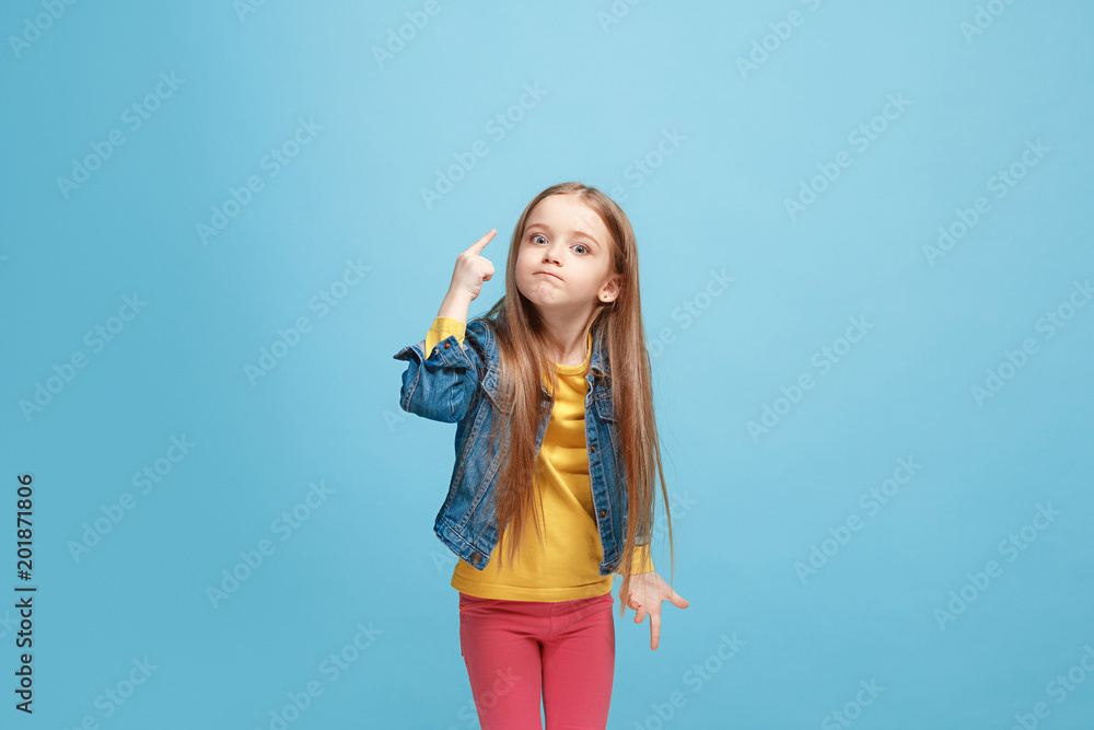 Beautiful female half-length portrait on blue studio backgroud. The young emotional teen girl Beautiful female half-length portrait on blue studio backgroud. The young emotional teen girl