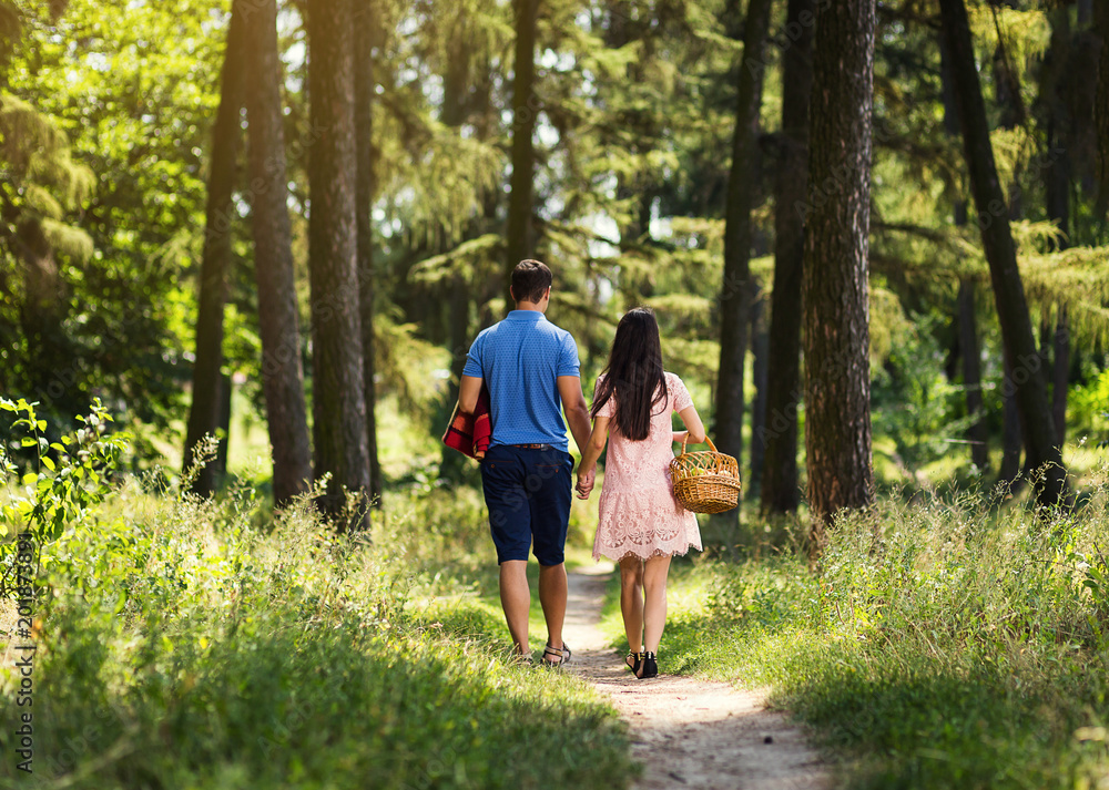 Fototapeta premium couple in love on dating holding hands and walkings in forest