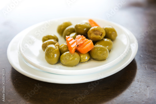 green olives in white bowl on table