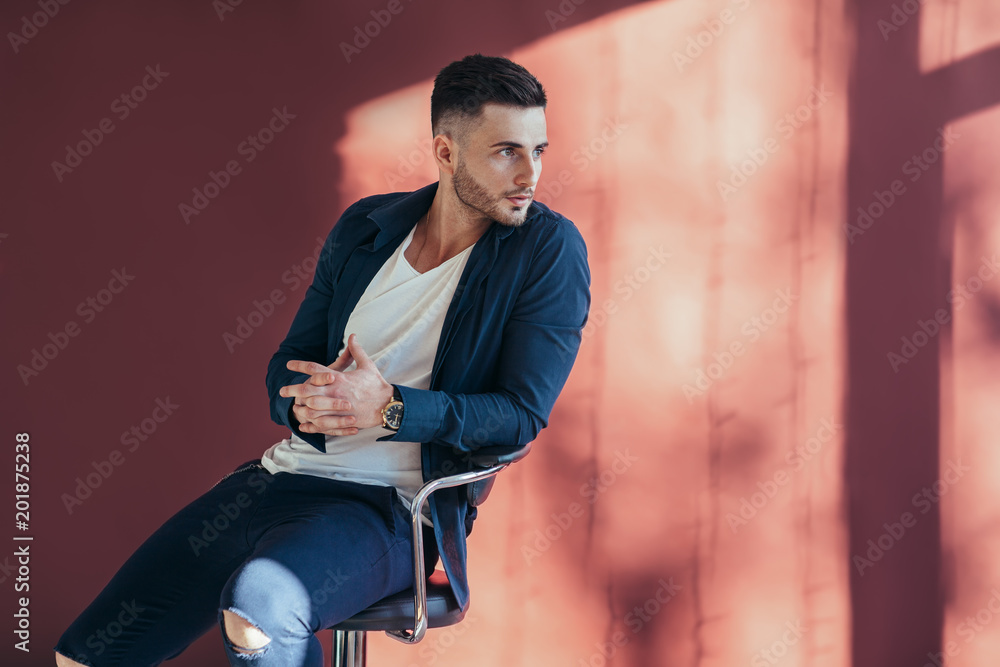 Portrait of confident and handsome man sitting on chair with copy space