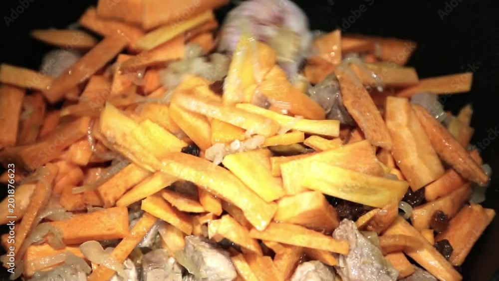 Preparation of rice dishes - pilaf from Uzbekistan. In a large saucepan roasts meat, garlic, carrots and spices. Preparation of rice dishes - pilaf from Uzbekistan. In a large saucepan roasts meat, garlic, carrots and spices.