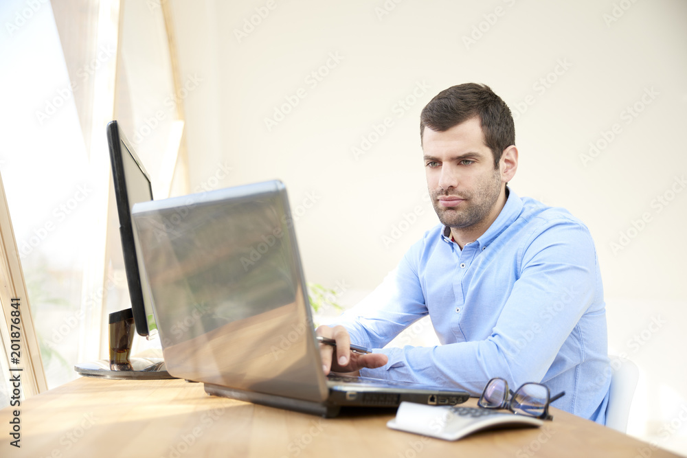 Thinking young businessman working on laptop Thinking young businessman working on laptop