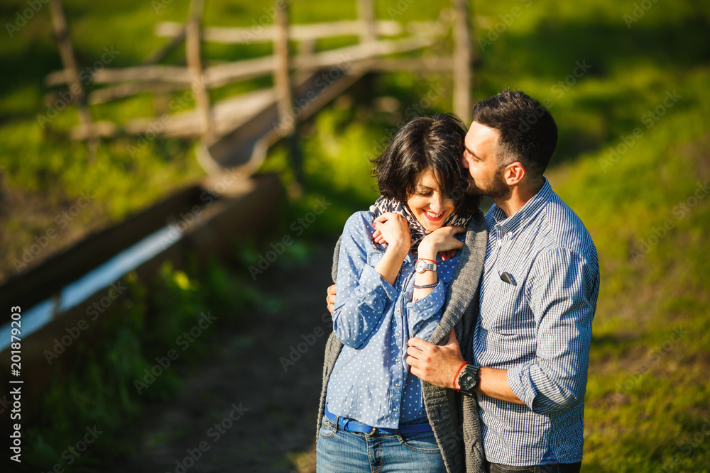 couple kissing in countryside meadow in the spring at sunset couple kissing in countryside meadow in the spring at sunset