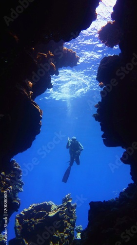 Underwater scenery, silhouette of diver in the deep blue water